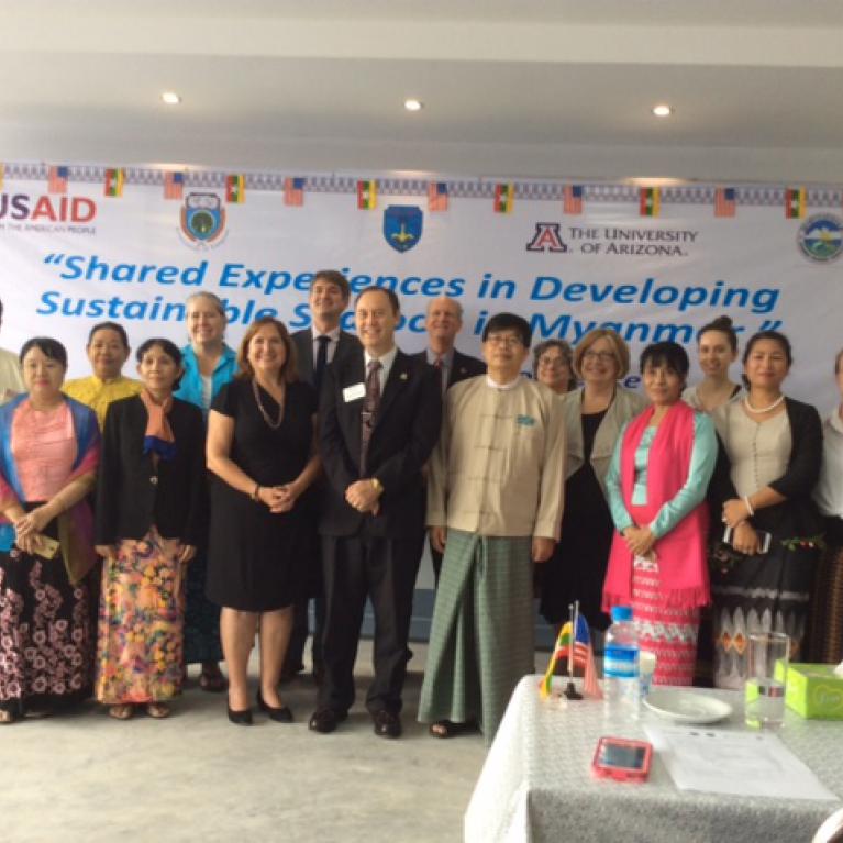 Group of men and women celebrating opening of international workshop at Yangon University.