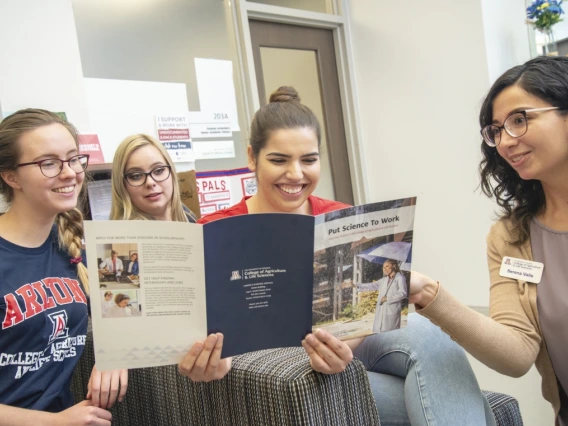 College advisor shares brochure with three students.