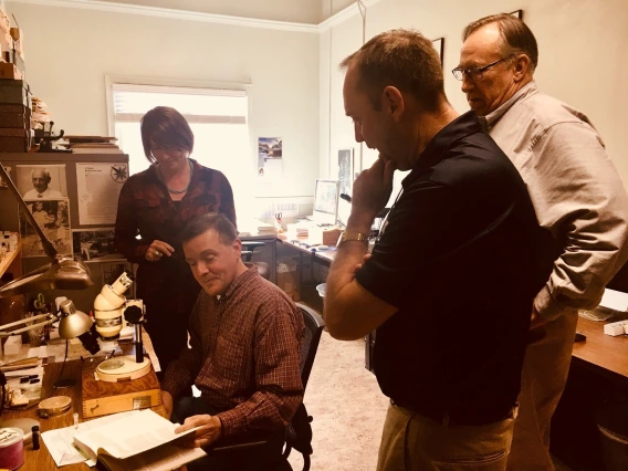 Vice President Burgess views equipment and reference guides used by UA Insect Collection personnel.